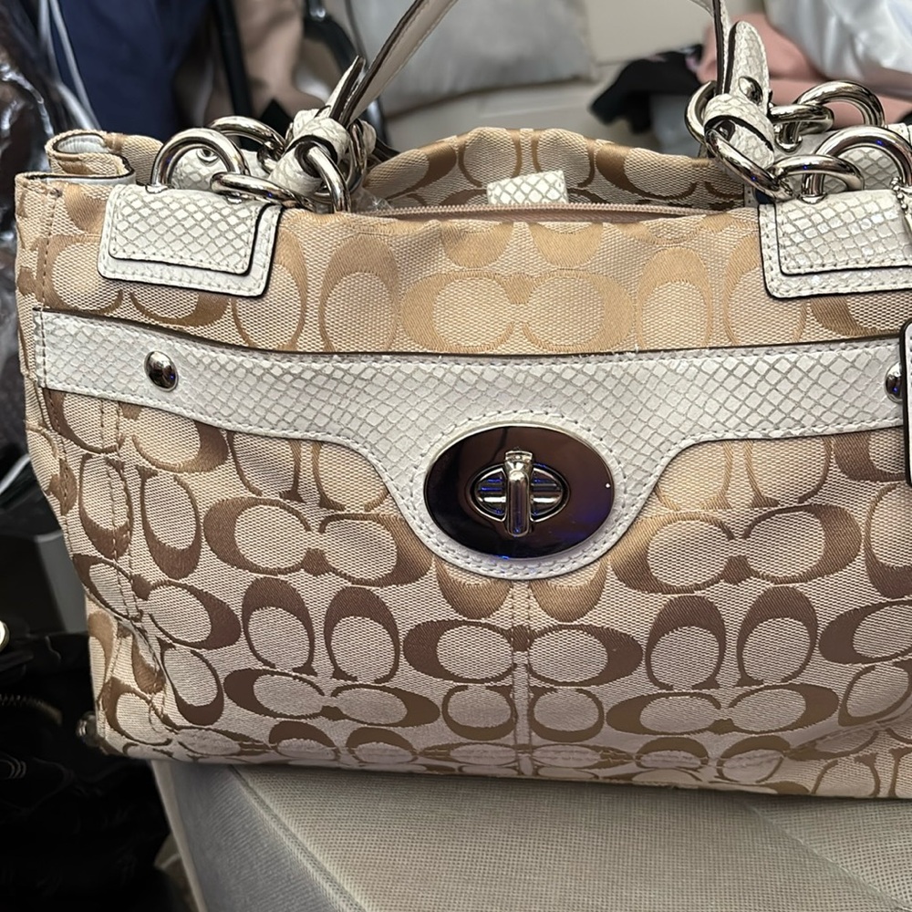 Cream and tan Coach with snake skin details. Twist lock in front.